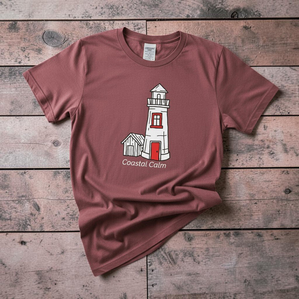 Lighthouse Coastal Calm brick garment-dyed tee on faded driftwood planks