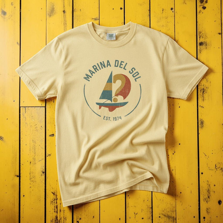 Marina Del Sol Sailboat banana garment-dyed tee on weathered wood planks