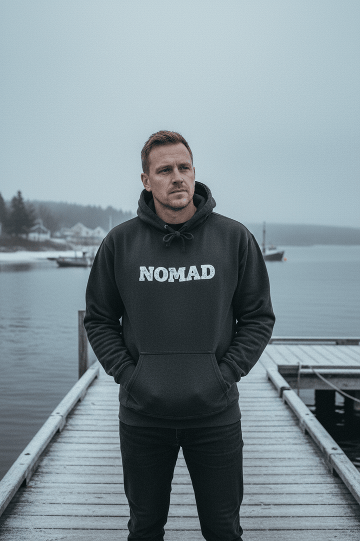 Male model wearing Nomad Garment-Dyed Hoodie in Pepper on a moody Maine winter coastal dock