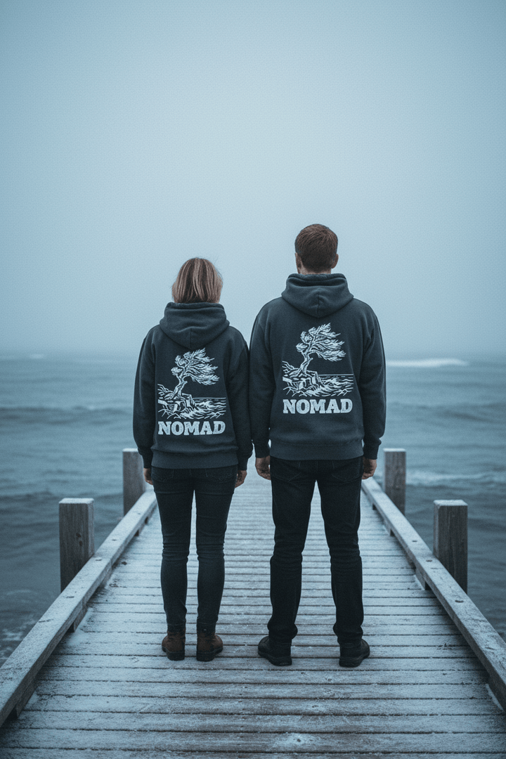 Couple showing the back of Nomad Garment-Dyed Hoodies in Pepper on a moody Maine winter coastal dock