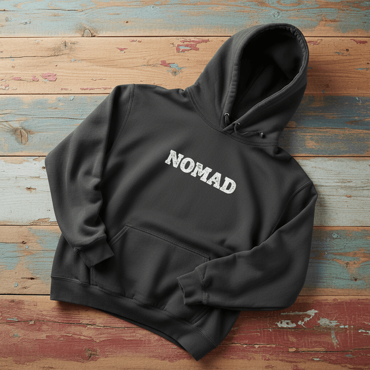 Nomad Garment-Dyed Hoodie in Pepper — front NOMAD chest graphic on driftwood
