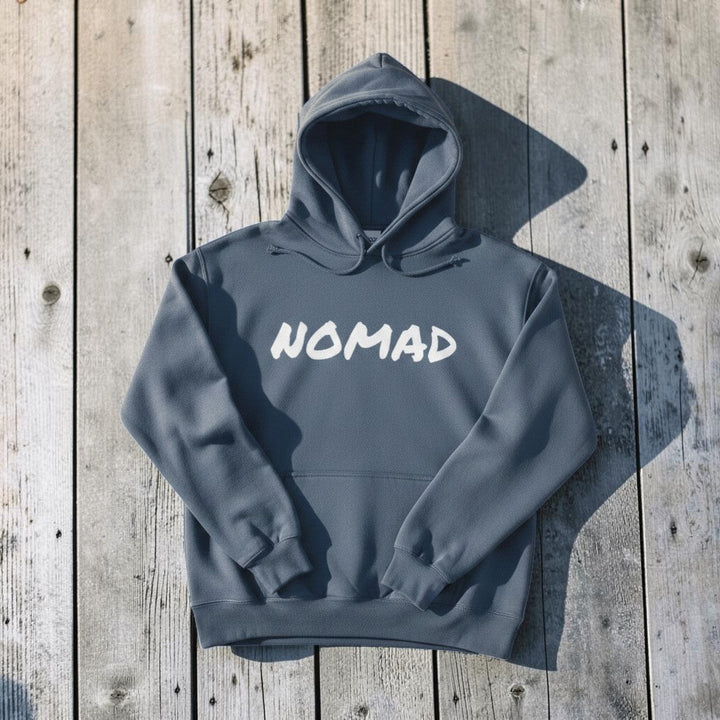 NOMAD Hoodie in Blue — front graphic, warm sand studio background