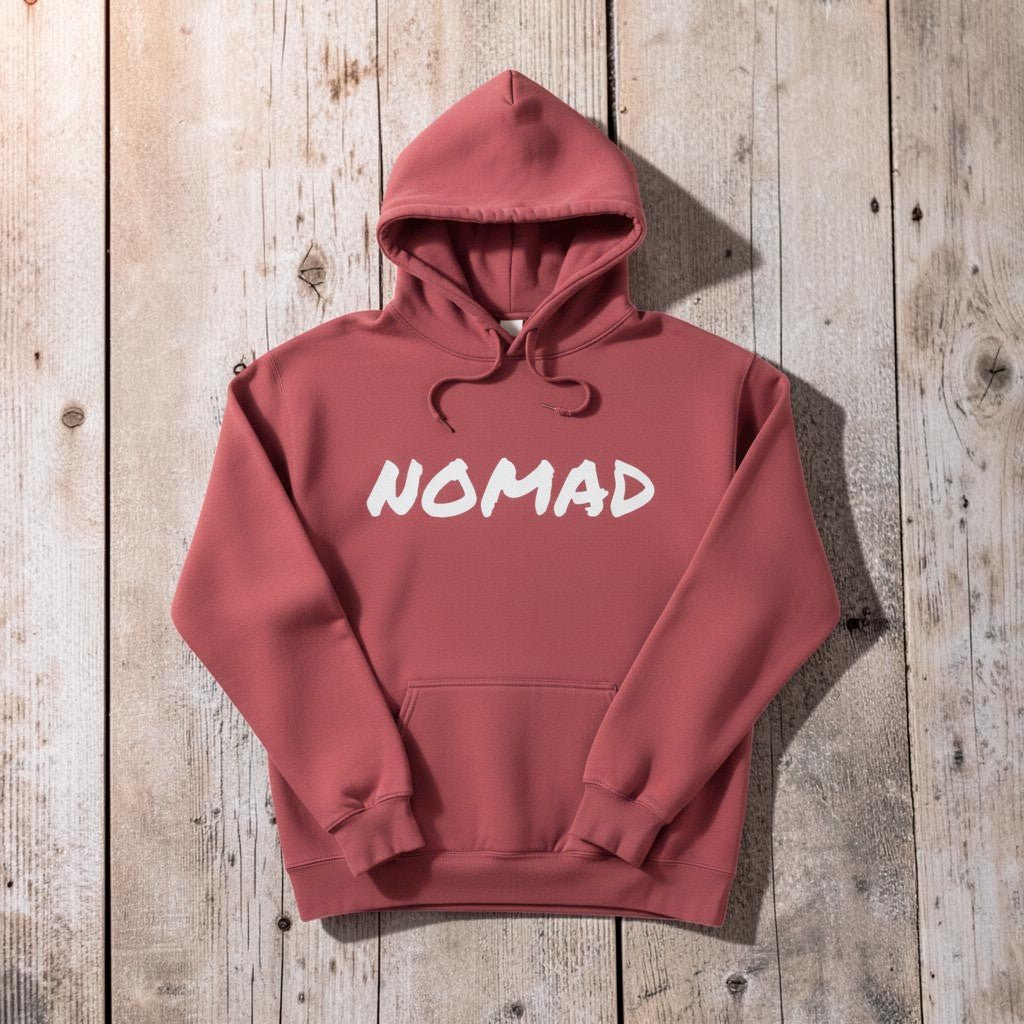 NOMAD Hoodie in Pink — front graphic, warm sand studio background