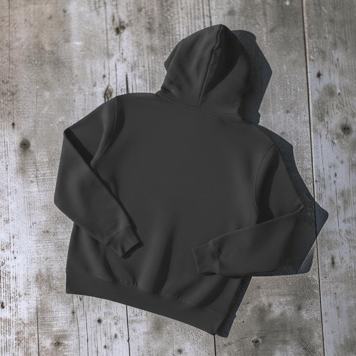 NOMAD Hoodie in Charcoal — plain back, warm sand studio background