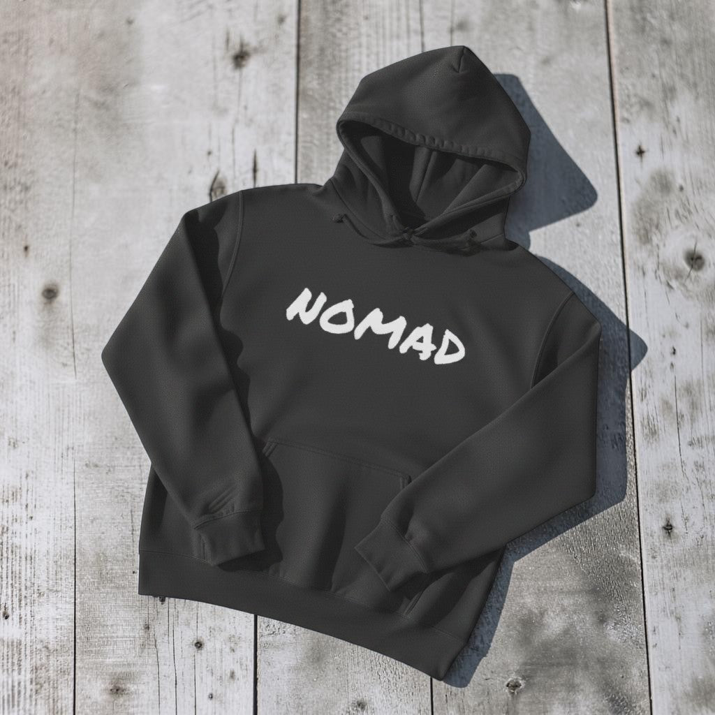 NOMAD Hoodie in Charcoal — front graphic, warm sand studio background