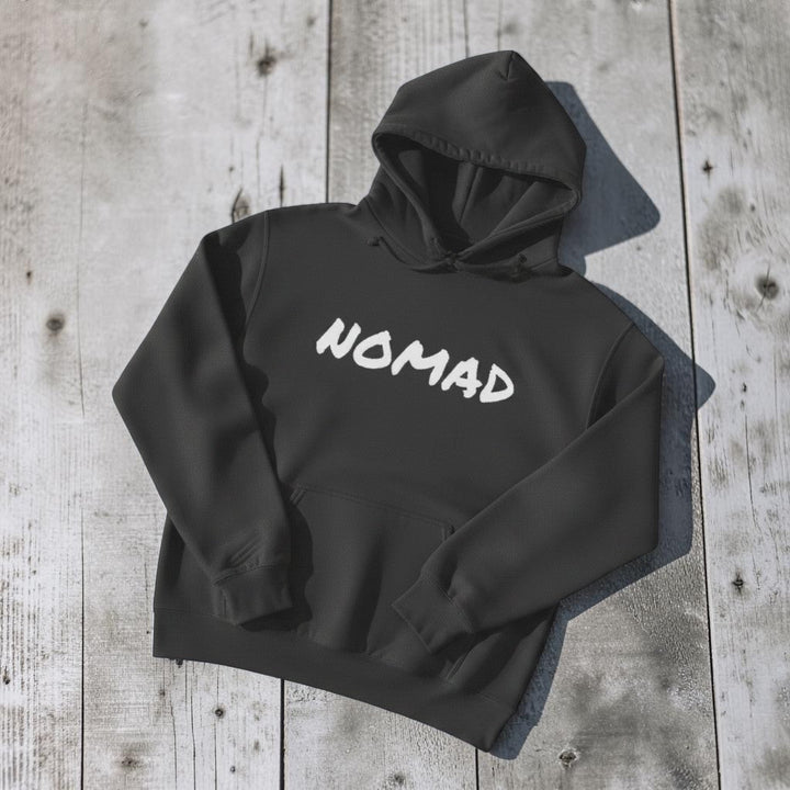 NOMAD Hoodie in Charcoal — front graphic, warm sand studio background