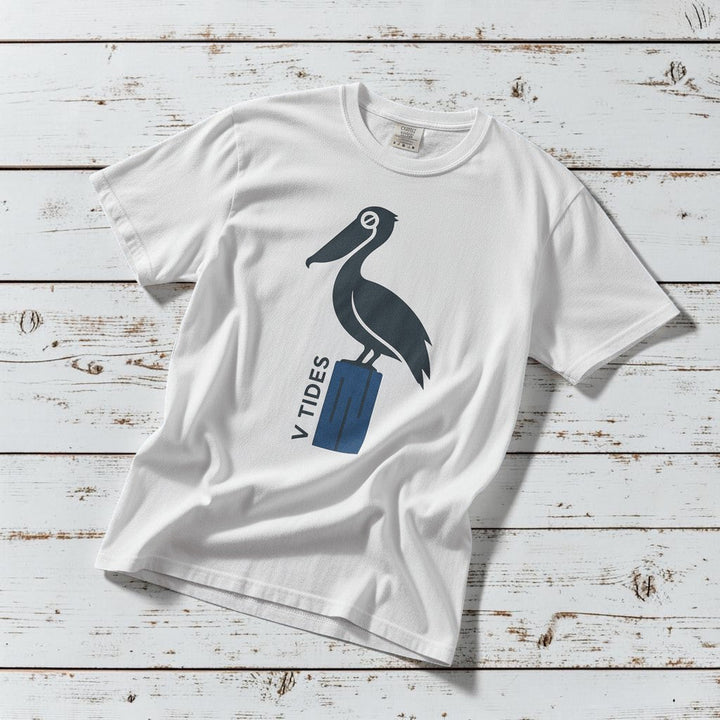 Pelican Dock V Tides coastal graphic t-shirt in White casually tossed on a light sand-colored woven rug, coastal