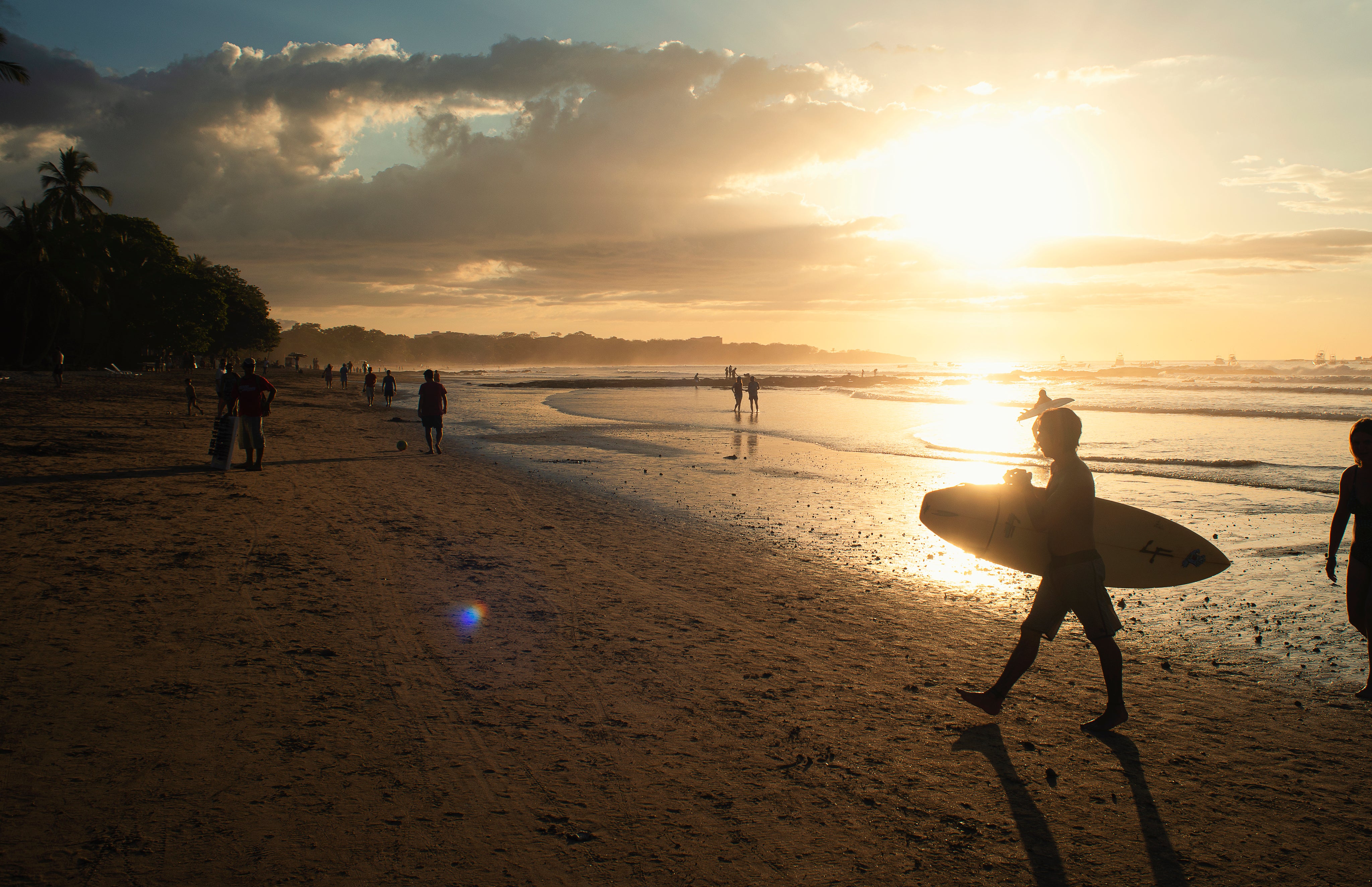 Surfers leaving beach at dusk