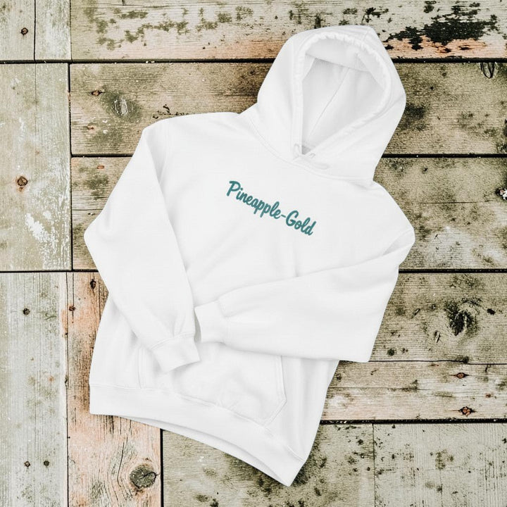 Pineapple-Gold Hoodie in White — front chest graphic, warm sand studio background