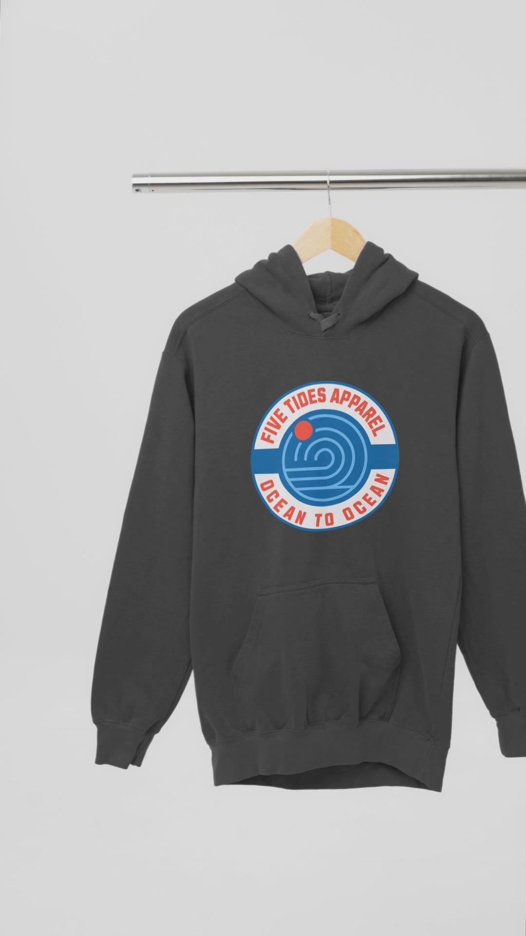 Load video: Charcoal video of the front of a pullover hoodie with a design by five tides and the hoodie is made by comfort colors.