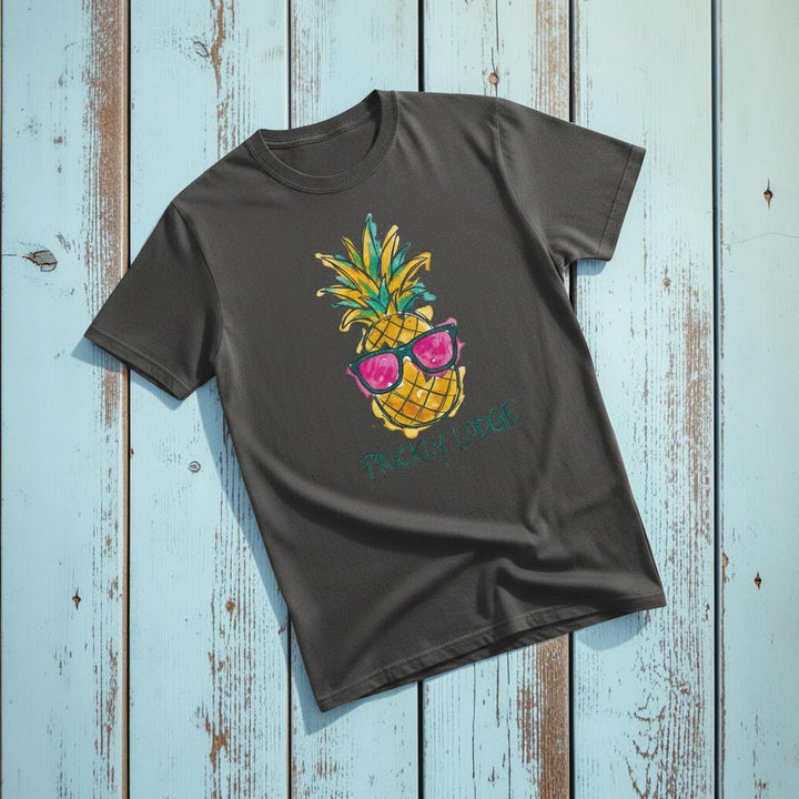 Prickly Lodge Pineapple Tee in Graphite — front graphic, warm sand studio background