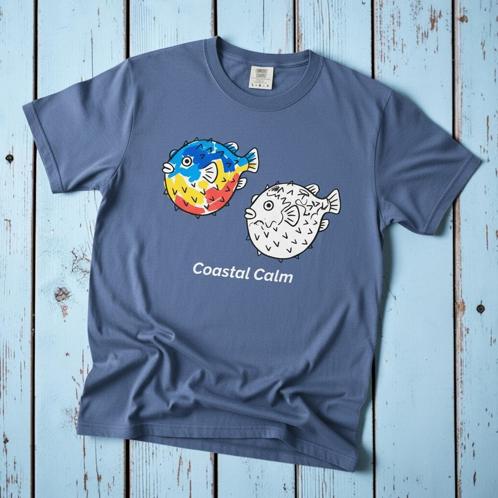 Puffer Fish Coastal Calm mystic blue garment-dyed tee on faded driftwood planks