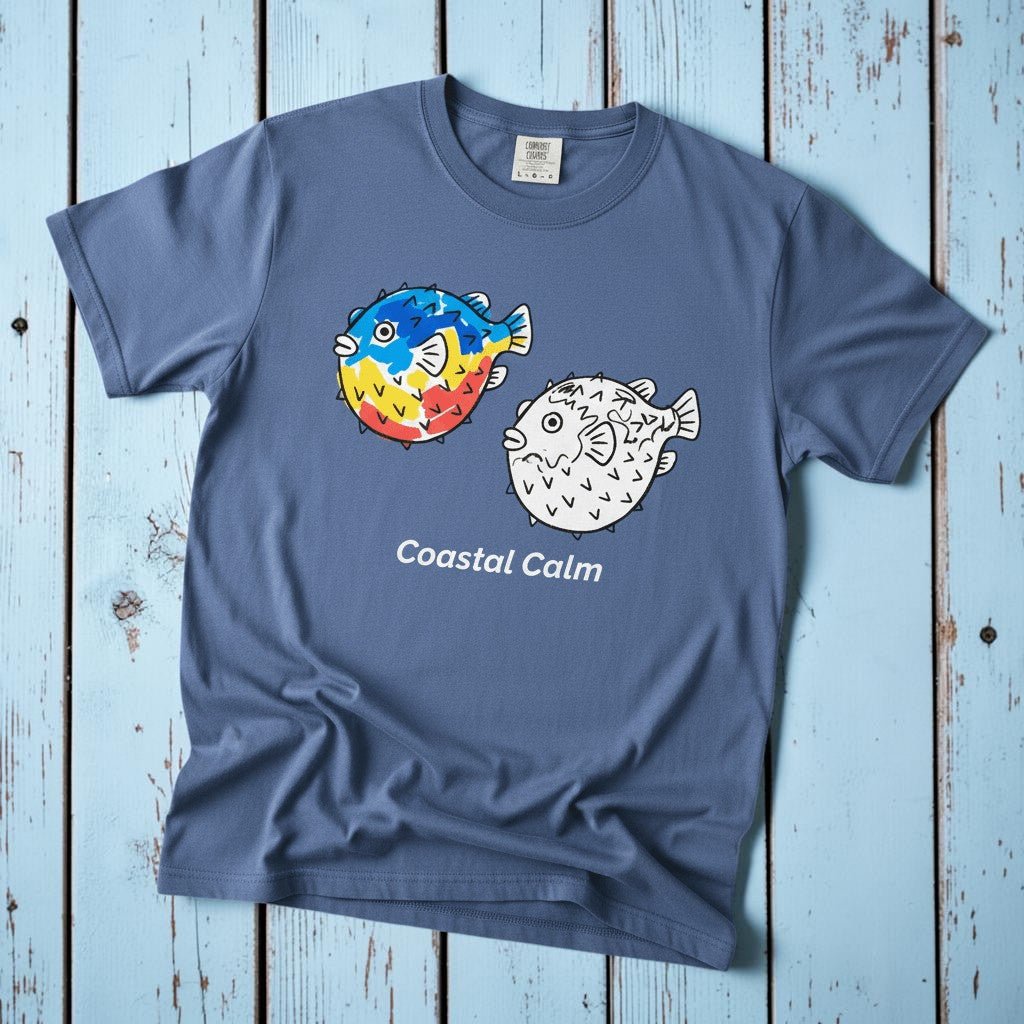 Puffer Fish Coastal Calm mystic blue garment-dyed tee on faded driftwood planks