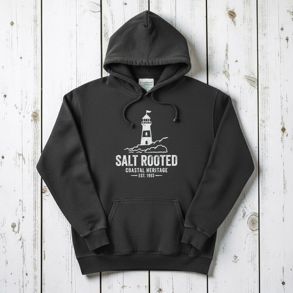 Pepper charcoal Salt Rooted lighthouse hoodie flat lay on weathered driftwood planks