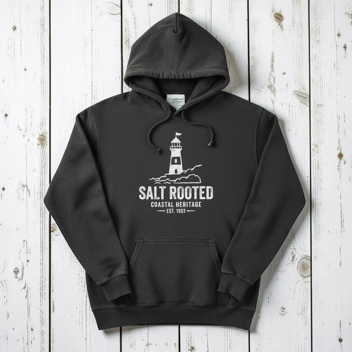 Pepper charcoal Salt Rooted lighthouse hoodie flat lay on weathered driftwood planks
