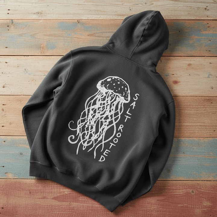 Salt Rooted Jellyfish Hoodie in Pepper Charcoal — back graphic with hand-drawn jellyfish and SALT ROOTED lettering on driftwood