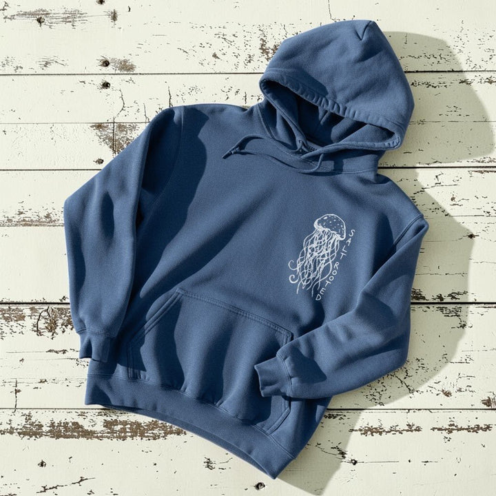Salt Rooted Jellyfish Hoodie in Blue Jean — front chest graphic with hand-drawn jellyfish on driftwood