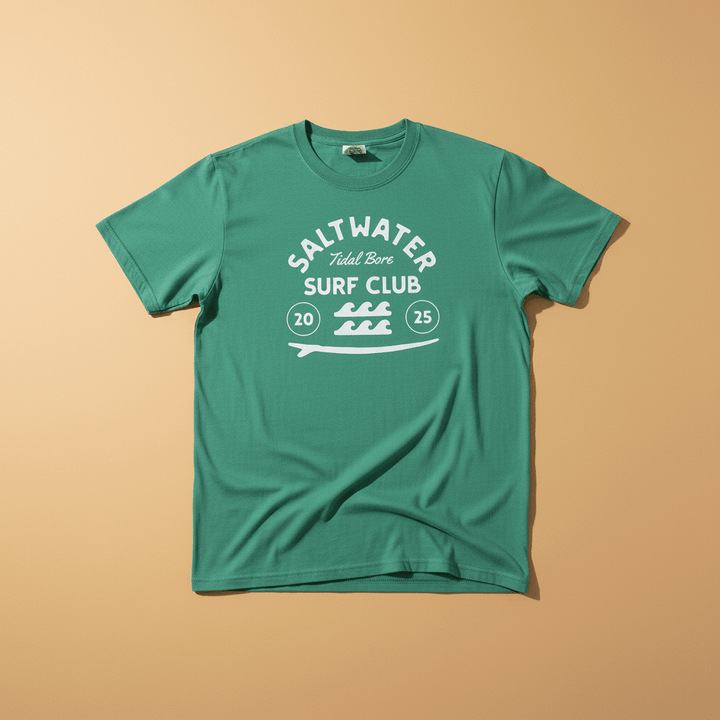 Saltwater Surf Club Tee in Island Green — front graphic, warm sand studio background