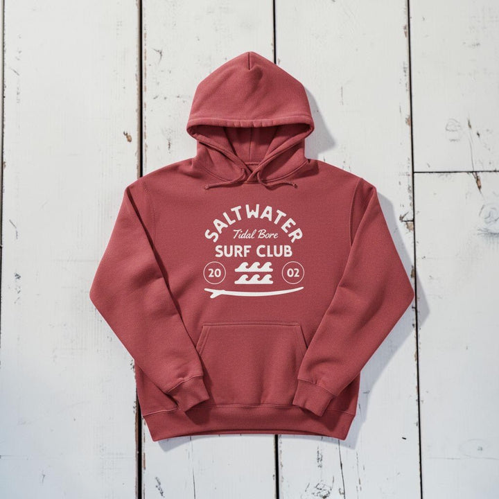 Saltwater Surf Club Hoodie in Crimson — front graphic, warm sand studio background