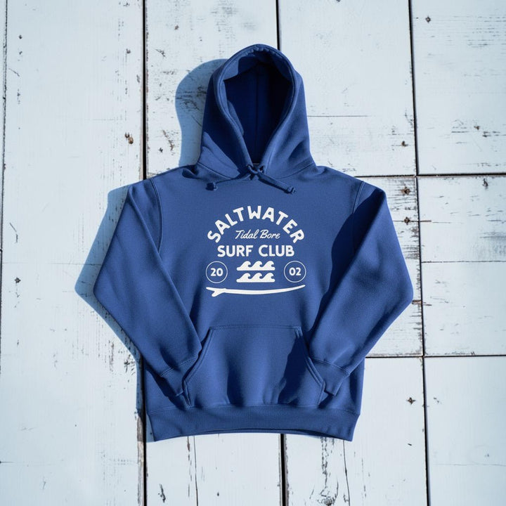 Saltwater Surf Club Hoodie in Flo Blue — front graphic, warm sand studio background