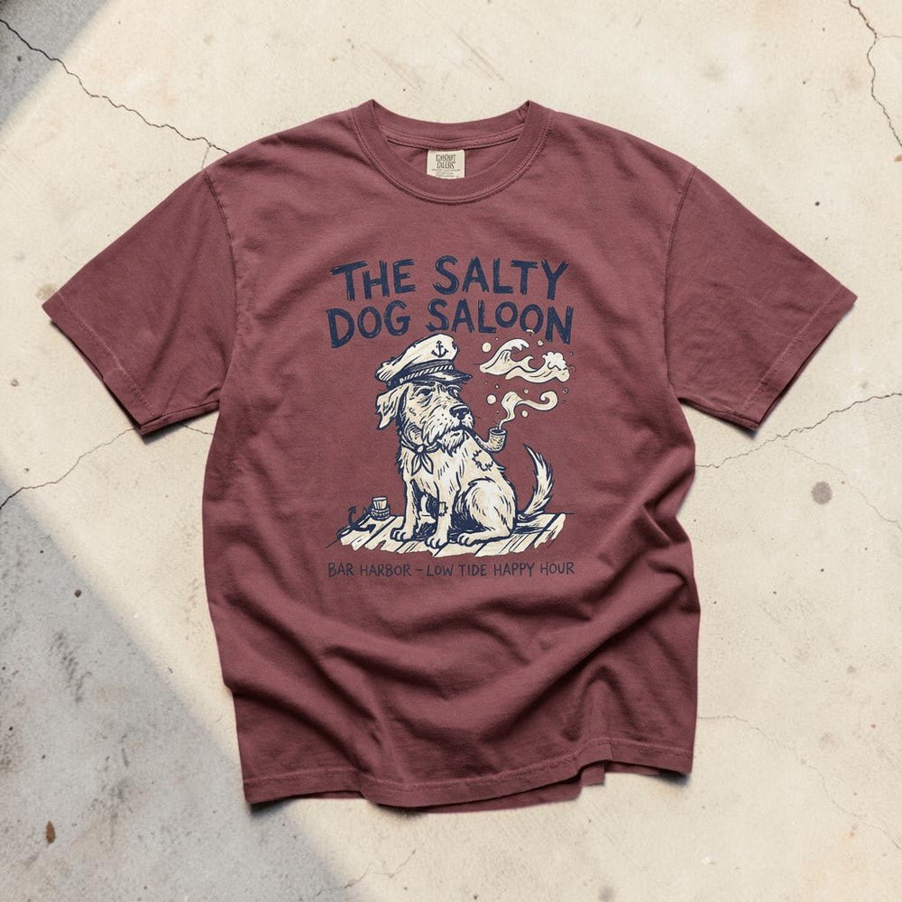Maroon t-shirt with 'The Salty Dog Saloon' graphic on a textured beige background