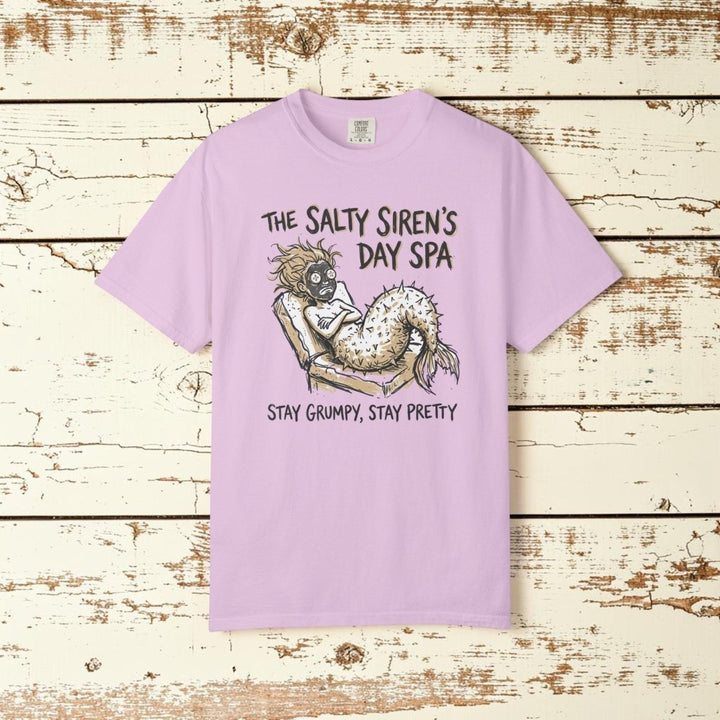 Pink t-shirt with a mermaid graphic and text on a white background