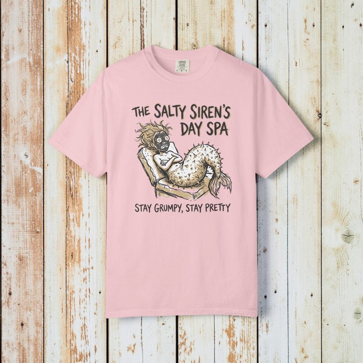 Pink t-shirt with mermaid graphic and text on a white background