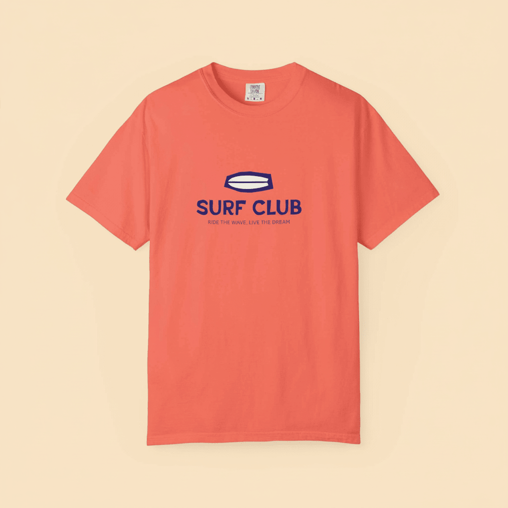 Surf Club Tee in Bright Salmon — front graphic, warm sand studio background