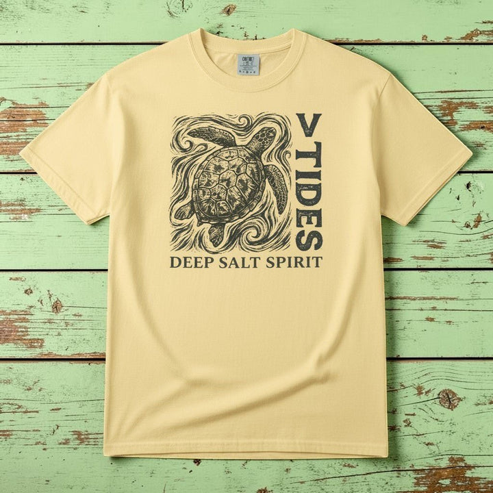 Flat lay - yellow V Tides Deep Salt Spirit tee on weathered driftwood planks