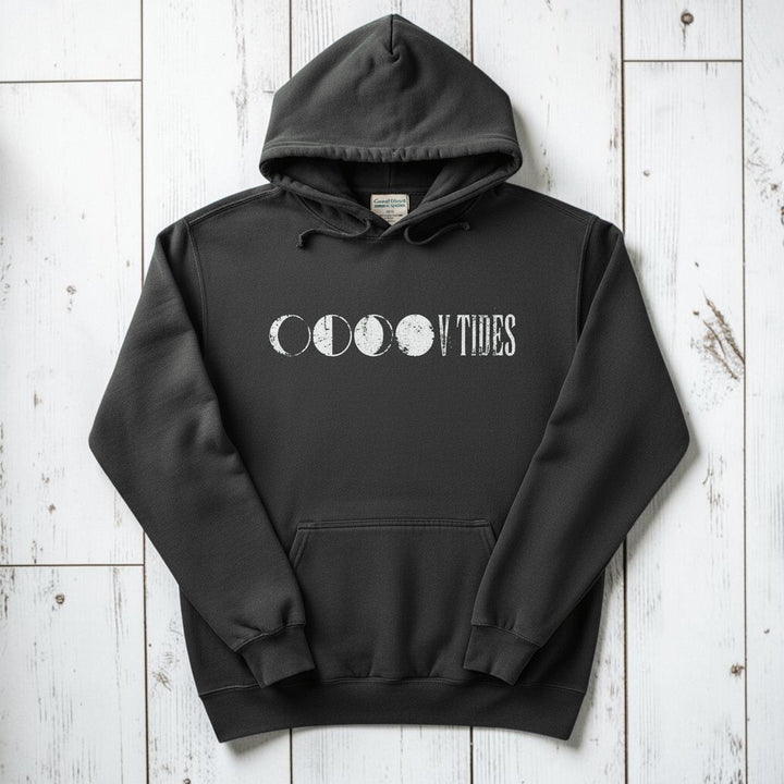 Pepper charcoal V Tides Moon Phases hoodie flat lay on weathered driftwood planks