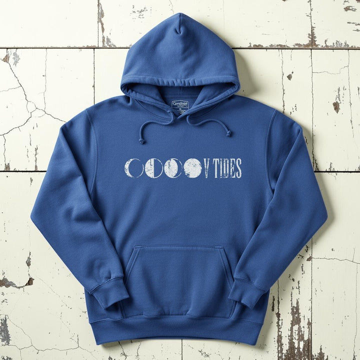 Flo Blue V Tides Moon Phases hoodie flat lay on weathered driftwood planks