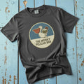 Flatlay - charcoal Wonky Pelican Bar tee on driftwood